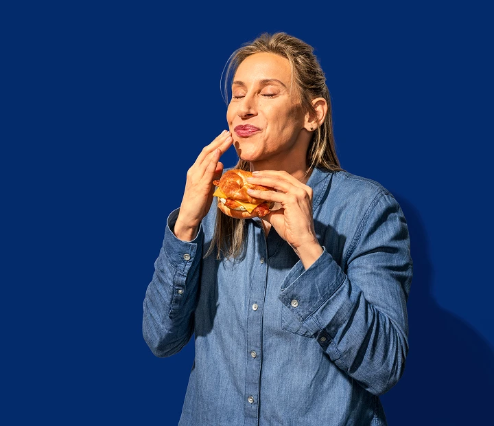 woman-eating-breakfast-sandwhich-section-hero-tall.webp